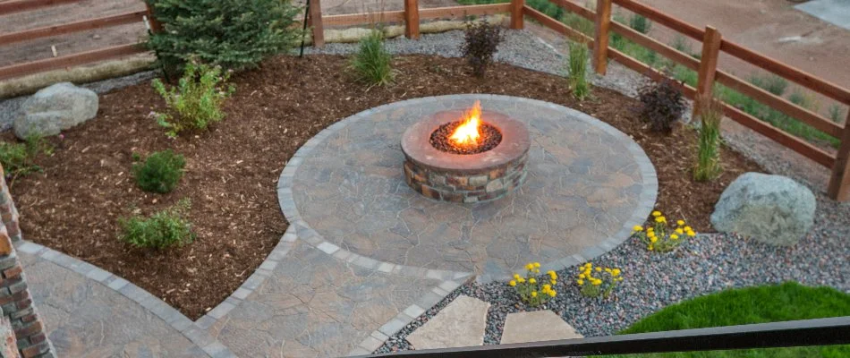 Round fire pit in Louisville, KY, surrounded by mulched landscape.