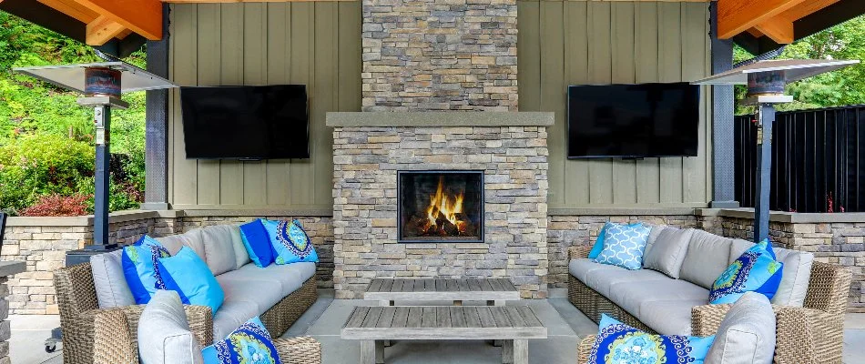 A burning outdoor fireplace with outdoor furniture in Louisville, KY.