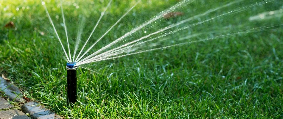Green lawn in Middletown, KY, with sprinkler for irrigation system.