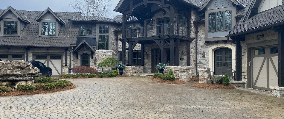 Luxury residential property with a beautifully landscaped driveway featuring stonework and greenery.