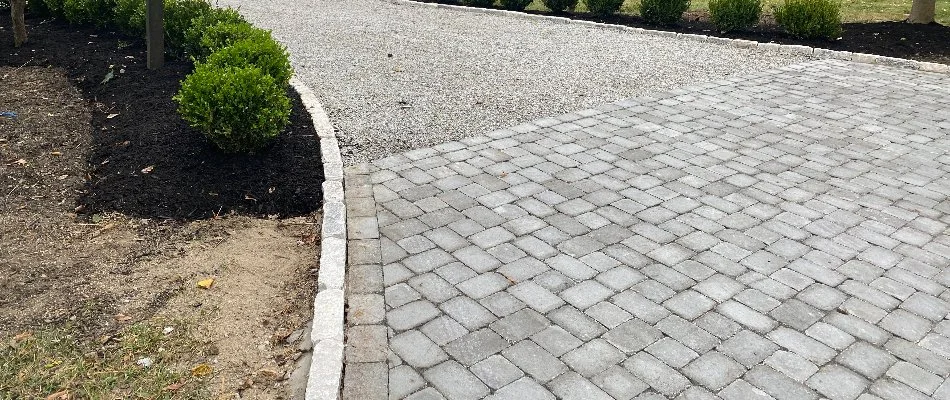 A paver driveway with surrounding landscaping.