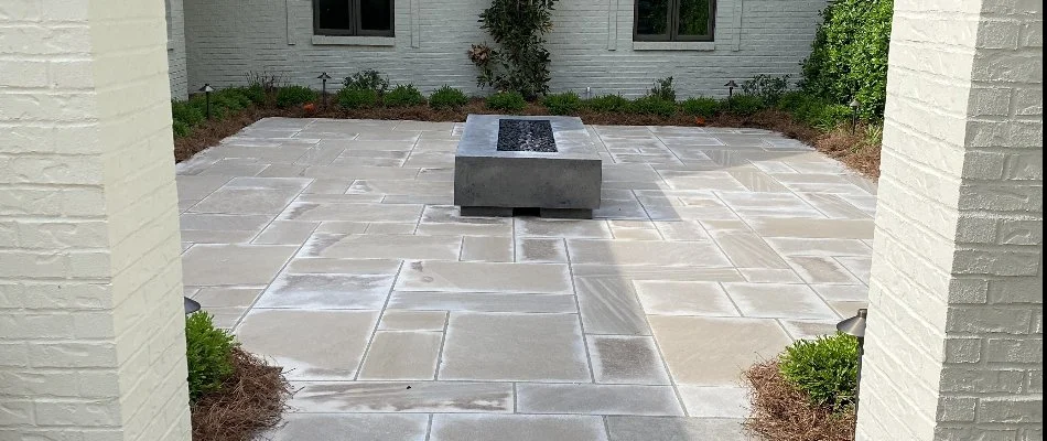 A paver patio with a gas fire pit in an outdoor living space.