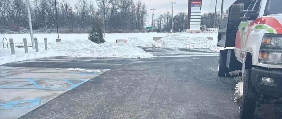 Parking lot with cleared asphalt and snow piles along the edges in Louisville, KY.