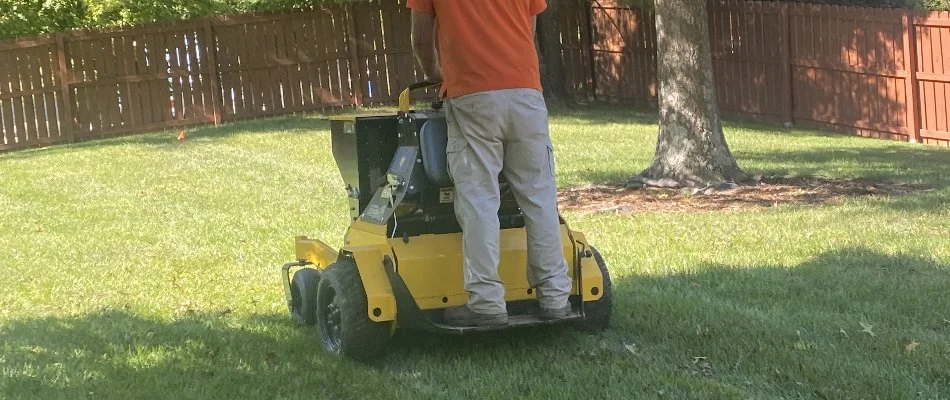 Tech riding an aerator across a lawn in West Buechel, KY.